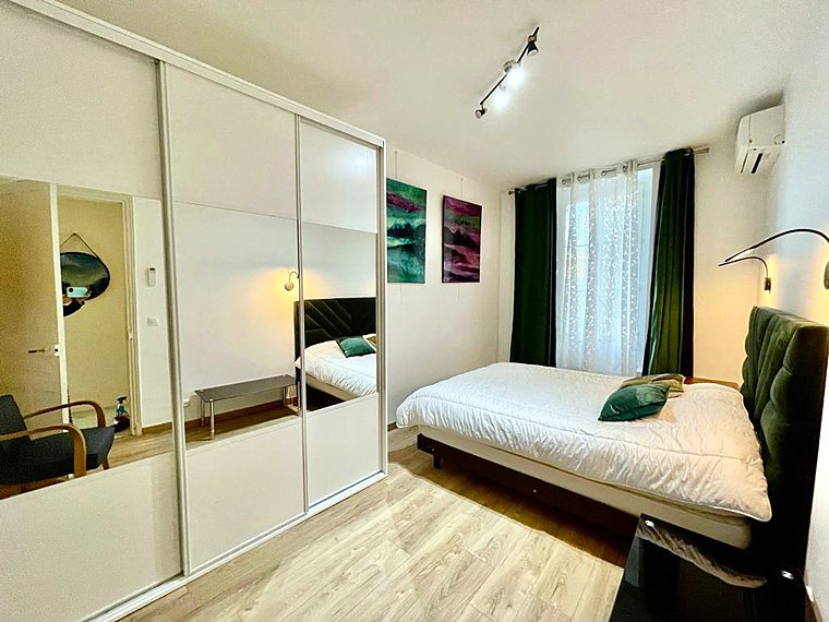 The Green room: white bed, green velvet headboard, green curtains and mirrored wardrobe