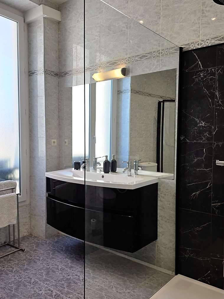 The bathroom, black lacquered double vanity and marble