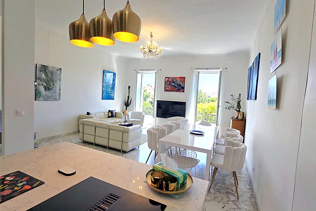 The living and dining room, light marble floor, white sofas and tall windows