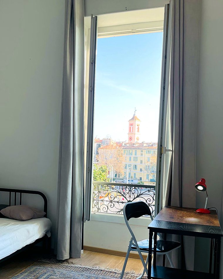 The bell tower and ochre rooftops of Nice, seen from the apartment’s tall windows